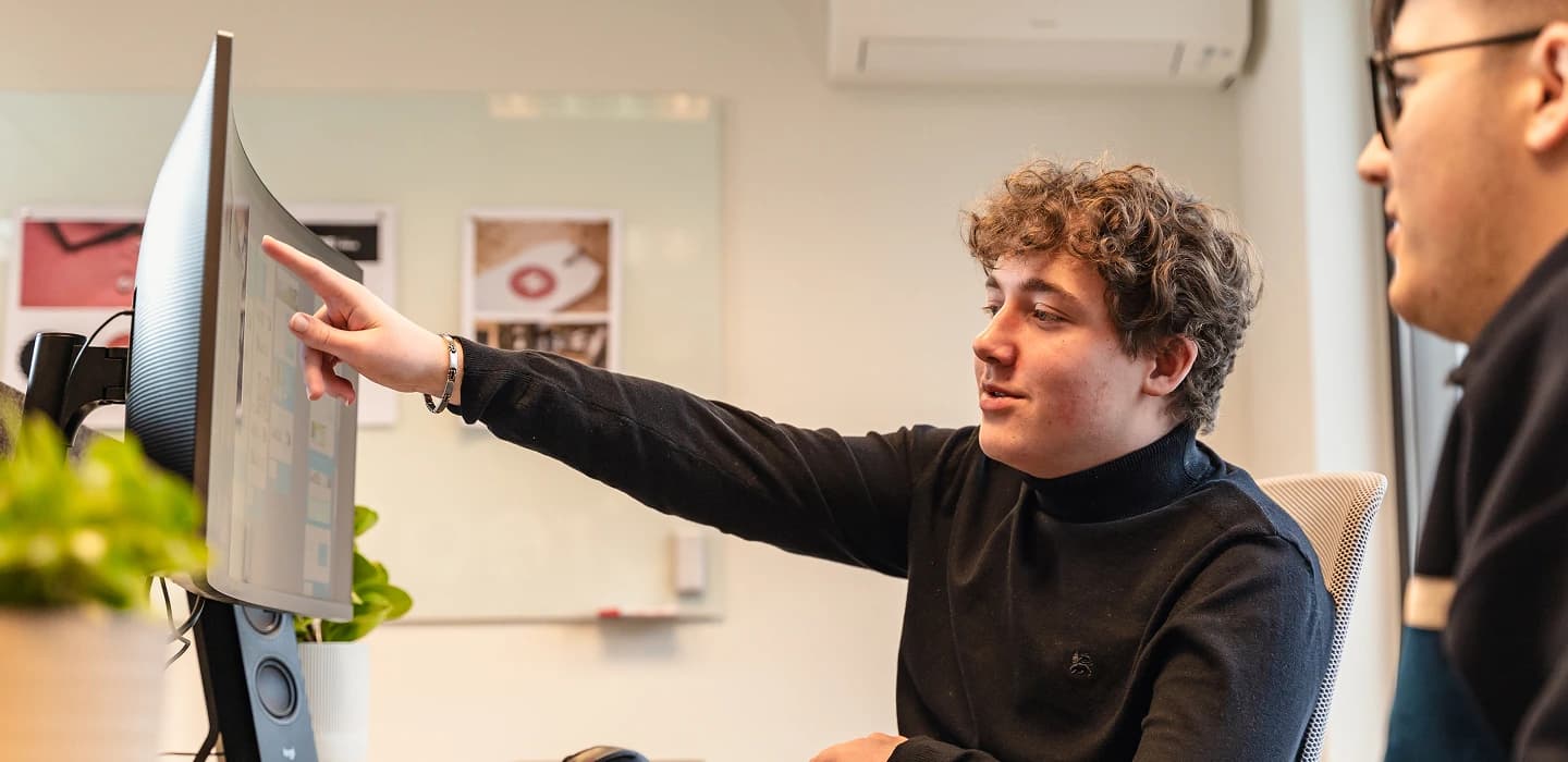 Medewerkers van Ovation bespreken een ontwerp tijdens een werksessie op kantoor